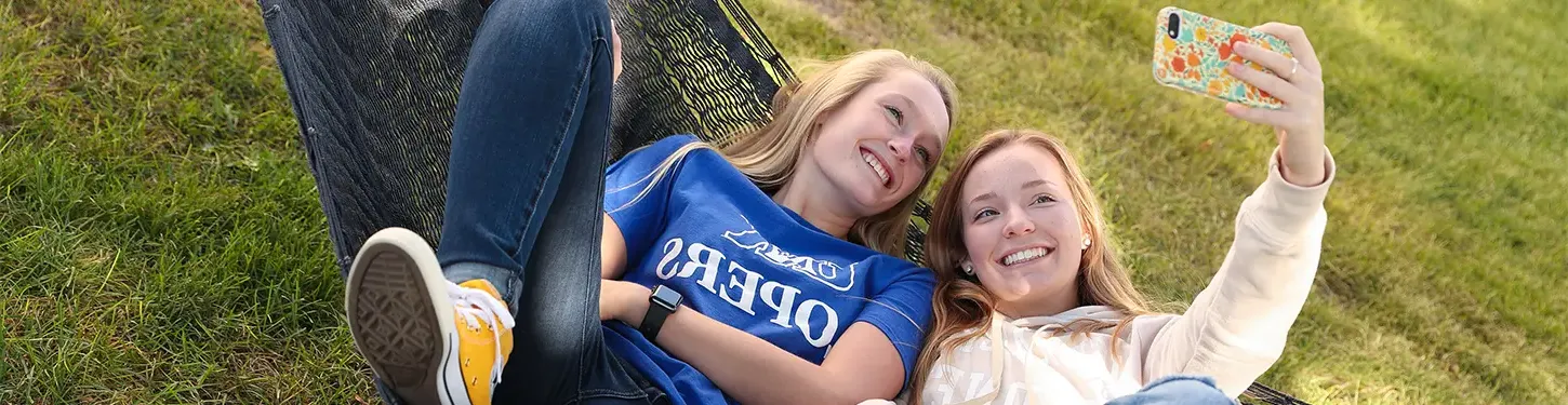 students taking a selfie in a hammock